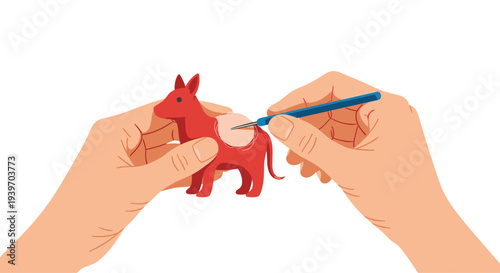 Two human hands are actively needle felting a small red animal figure, adding a light-colored patch to its side with a single tool.