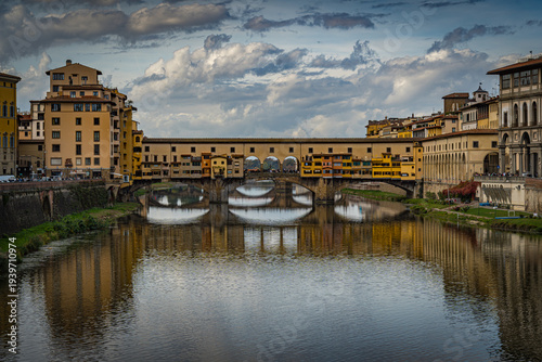 View of Ponte Vecchio and buildings along the Arno River in Florence during a cloudy afternoon
