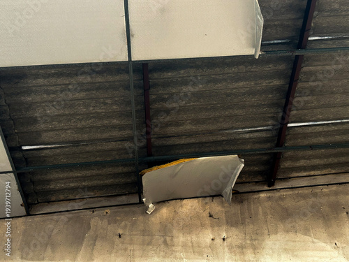 Fotografi Damaged ceiling panels revealing old asbestos roof