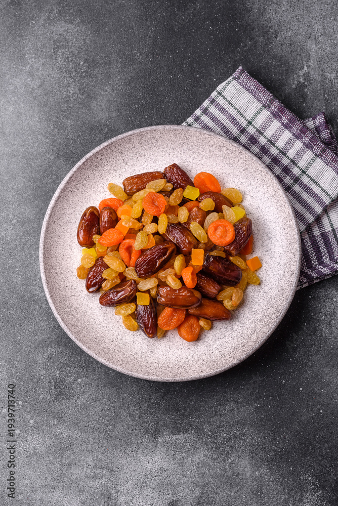 Fototapeta premium Dried apricots, raisins, and candied fruits as ingredients for baked goods and sweets. Dried fruits