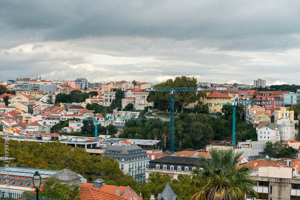 Obraz premium panoramic cityscape of lisbon with red rooftops and dramatic clouds