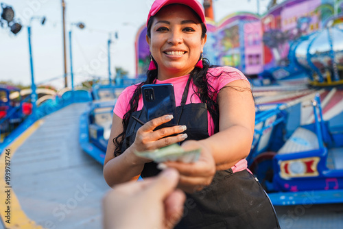 Confident latin woman entrepreneur receiving payment at amusement fair