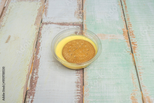 Fotografie A deep plate of custard, showing a spoon that has just taken the first bite, leaving a clean indentation and showing that it's creamy, not runny