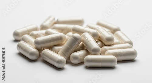 A pile of white gelatin capsules on a plain background for medical or supplement use
