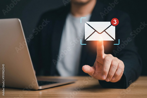 Wallpaper Mural Businessman interacting with email notification icon showing unread messages next to a laptop symbolizing digital communication and online alerts. Torontodigital.ca