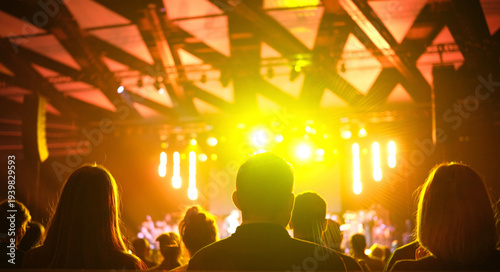 фотографія Bright stage lights shine on audience members at a lively concert taking place i