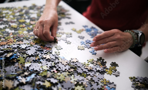 Female Hands Assembling A Puzzle On A Table At Home