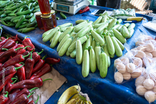 Fresh zucchini, red peppers, cucumbers and organic eggs at a local farmer's market stall