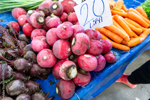 Fresh red radishes and beetroots with price tag at a traditional farmer's market