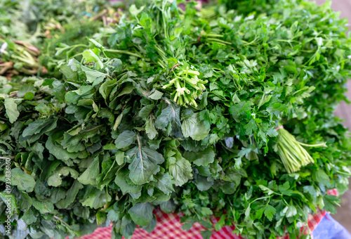 Fresh bunches of green parsley and arugula at a local farmer's market