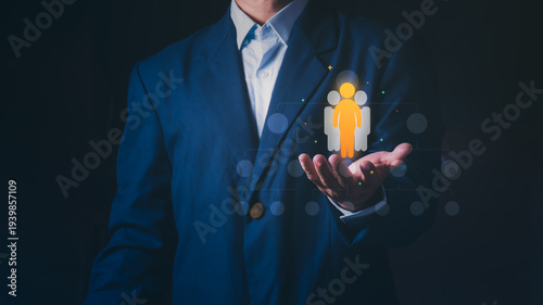 Businessman holding a glowing human resource icon over a corporate hierarchy, Concept of talent acquisition, recruitment, human capital management, and leadership selection