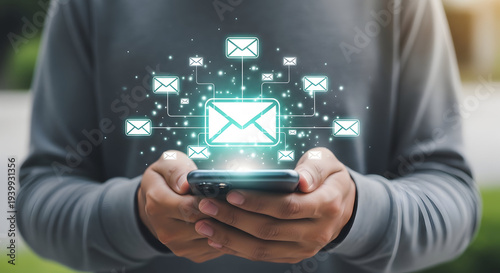 Hands holding smartphone with glowing email network overlay