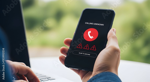 Hands holding smartphone with unknown caller warning on screen