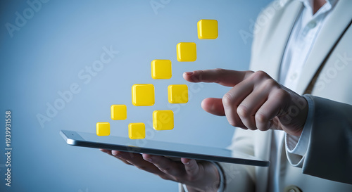 Hands holding tablet with ascending yellow squares virtual interface