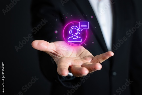 Businessman holding hand with glowing purple customer service icon and chat bubble