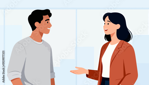 Two people converse warmly in a bright, modern office. They smile, suggesting friendly or professional interaction. The woman gestures, indicating openness or explanation. The man listens attentively