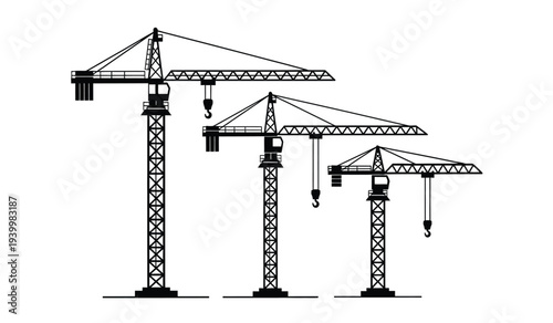 Three construction cranes of varying heights