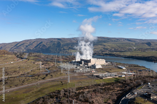 Aerial drone picture of a large data center campus with cooling steam, electrical substation along the Columbia River in The Dalles, Oregon, USA. Power demand for cloud computing AI infrastructure