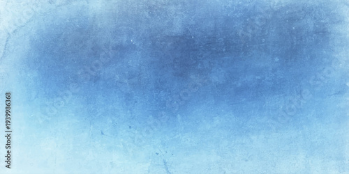 A blue grunge abstract background features a vintage textured paper pattern with dark and light paint splatters on a rough aged wall for a retro dirty canvas design