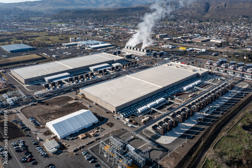 Aerial drone picture of a large data center campus with cooling steam, electrical substation along the Columbia River in The Dalles, Oregon, USA. Power demand for cloud computing AI infrastructure