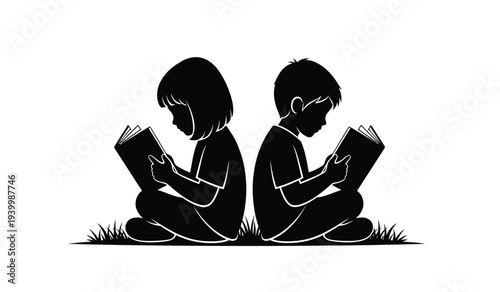 Two children sitting on grass reading books together in silhouette