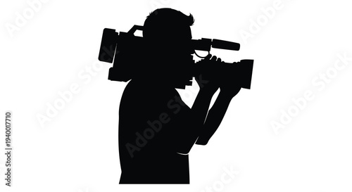A dark silhouette of a man operating a professional video camera focused on capturing a scene silhouette