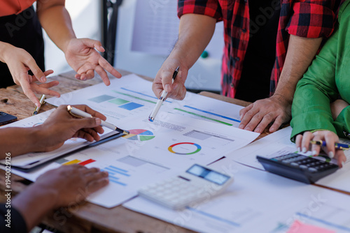 Obraz na płótnie A team of professionals actively engages with business reports, demonstrating collaboration and the analytical approach needed to understand their project's status and results