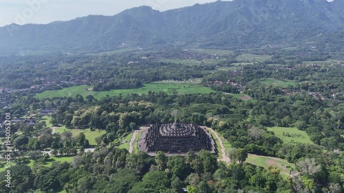 Aerial drone fly-in to Borobudur temple, the world largest Buddhist monument at sunrise, Central Java, Indonesia
