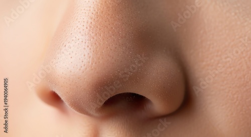 Close-up of a person's nose and surrounding skin texture with natural lighting.