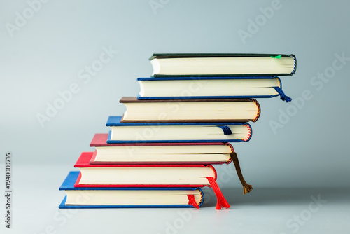 Stack of colorful hardcover books arranged like steps symbolizing learning progress and education