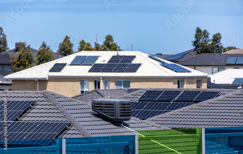 Residential rooftops fitted with solar panels in a suburban neighborhood in Australia. Multiple houses generate renewable energy using photovoltaic systems, growing adoption of solar power
