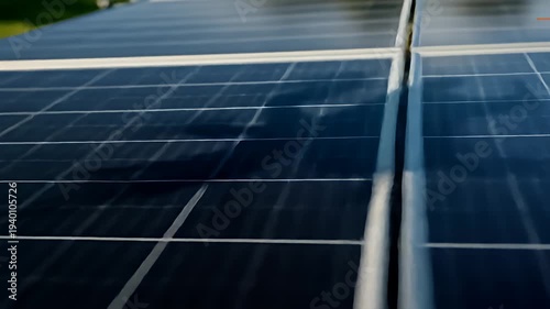 Close-up view of solar panels reflecting sunlight, with shadows of people in the background