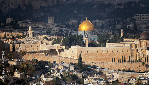 Jerusalem skyline in 2026, Israel. View of the historic city with the iconic Dome of the Rock rising above the Old City, surrounded by ancient stone architecture under natural daylight. A timeless sce