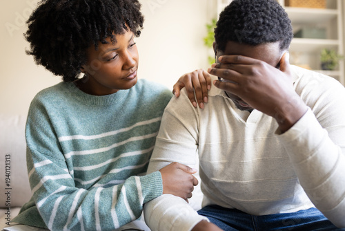 Fotografi Young black woman comforting sad man at home
