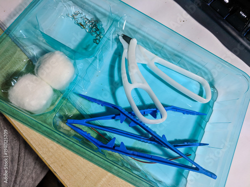 Kit to remove stainless steel metal clips used instead of stitches for surgery, including tweezers, cutters and cotton balls.