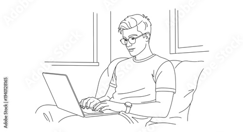 Young man with glasses working on a laptop while sitting on a couch at home