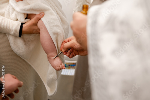 Obraz na plátne Priest anointing newborn baby foot with holy oil during orthodox baptism ceremon