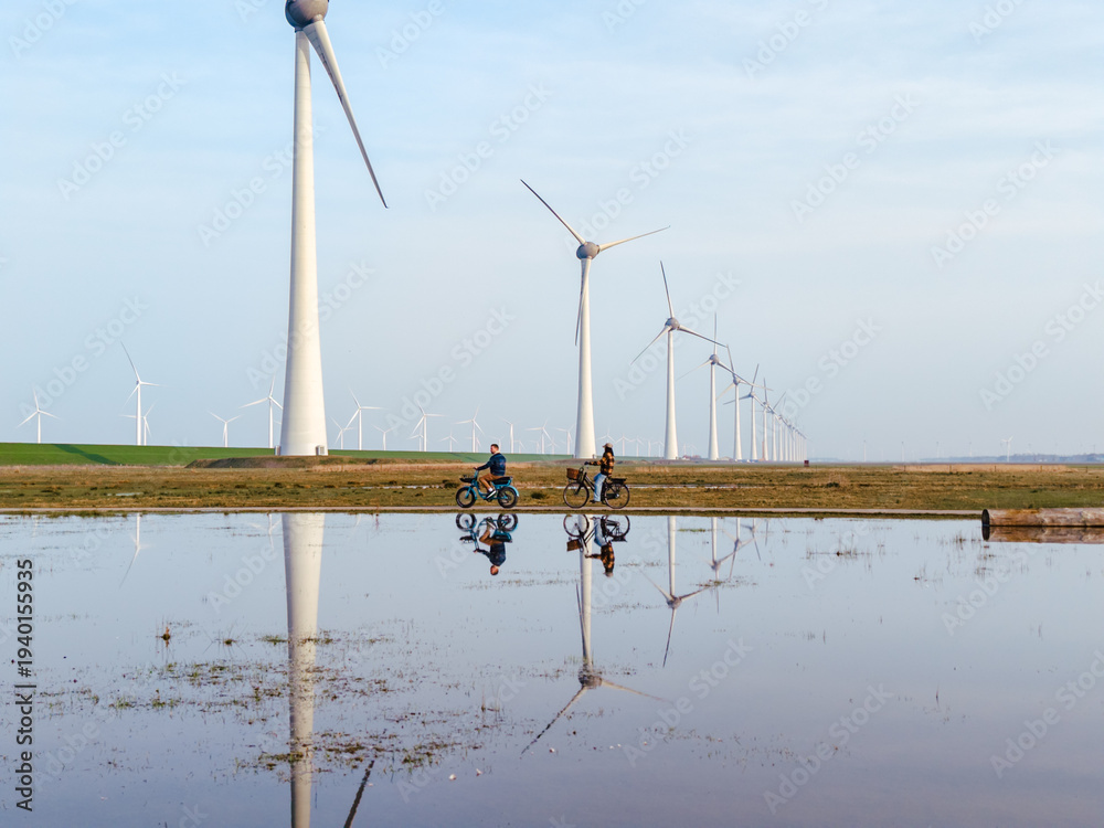 Fototapeta premium Exploring the serene landscape of Urk with wind turbines reflecting in calm waters