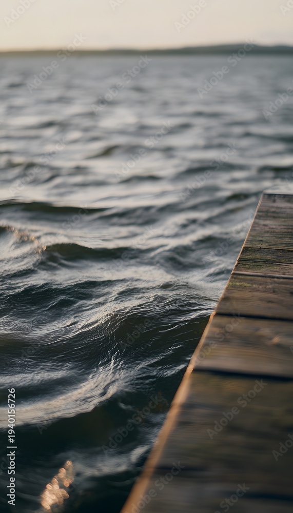 Fototapeta premium Tranquil summer waves meet an old pier bathed in golden light a peaceful serene landscape view