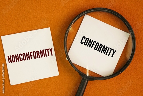 Foto A magnifying glass with the two words Conformity and Nonconformity