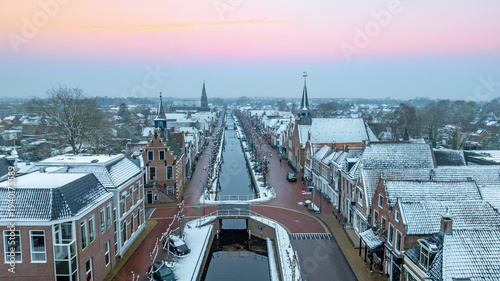 Canvas-taulu Snowy historic European village canal at sunset