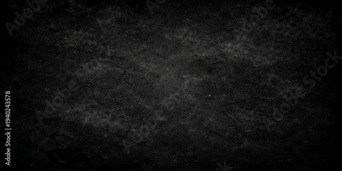 Abstract black and white paper texture with a dark grunge chalkboard pattern and a rough vintage stone wall surface design for a blank gray backdrop
