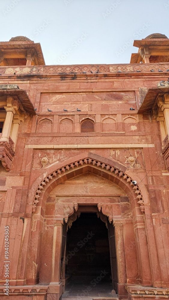 Fototapeta premium Historic Red Sandstone Arch Entrance in India – Mughal Style Heritage Architecture