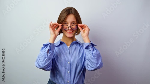 Beautiful girl holding glasses for vision winking playfully with smile flirty young woman with eyeglasses fun interaction happy expression studio portrait optics