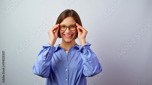 Young girl trying on glasses for vision and smiling happy to see well now joyful woman with eyeglasses successful purchase clear sight positive emotions studio