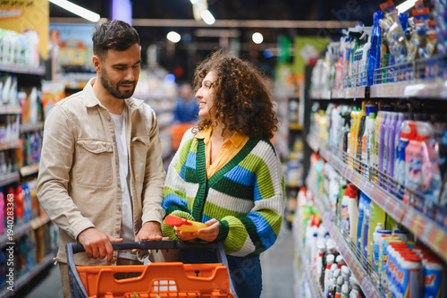 Vászonkép Couple shopping for cleaning supplies in supermarket aisle