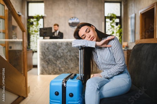 Bild auf Leinwand Tired woman sleeping in hotel lobby experiencing jet lag