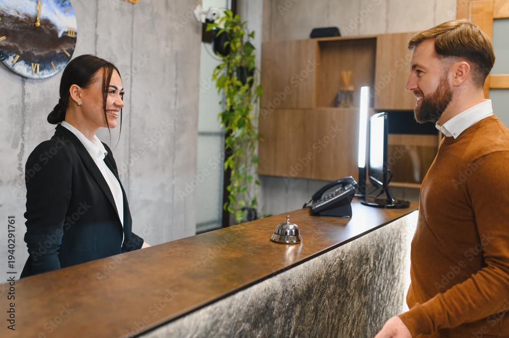 Fototapeta premium Hotel receptionist assisting guest during check in process