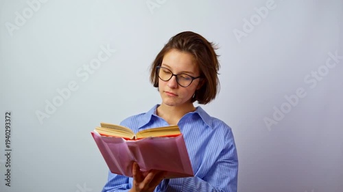 Beautiful girl in glasses for vision learning reading textbook young woman with eyeglasses studying education student with book knowledge focus studio portrait