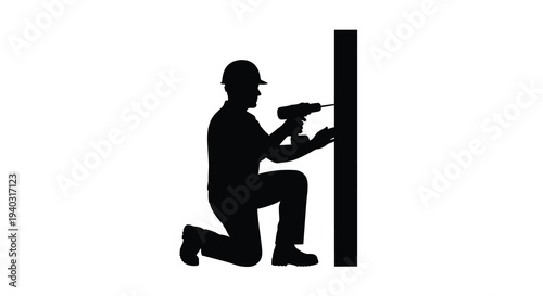 Construction worker kneels and drills into wood a striking silhouette